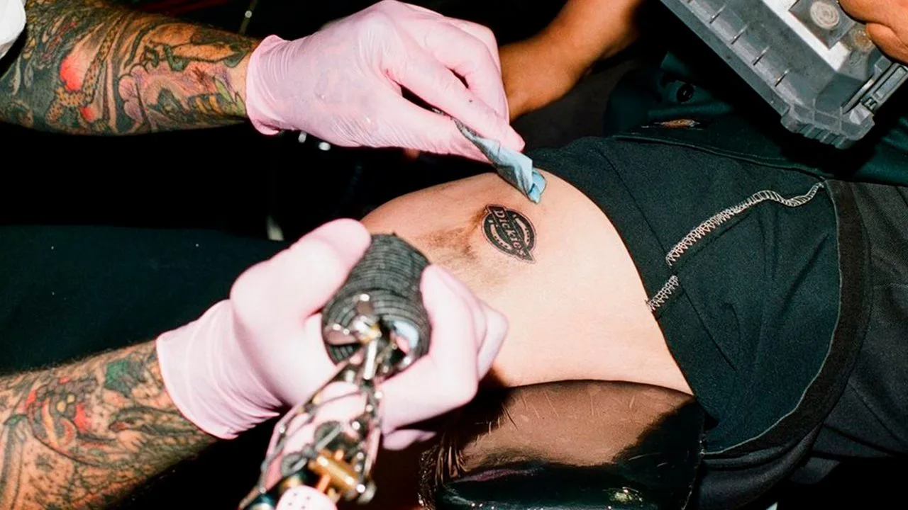A Dickies logo tattoo in progress