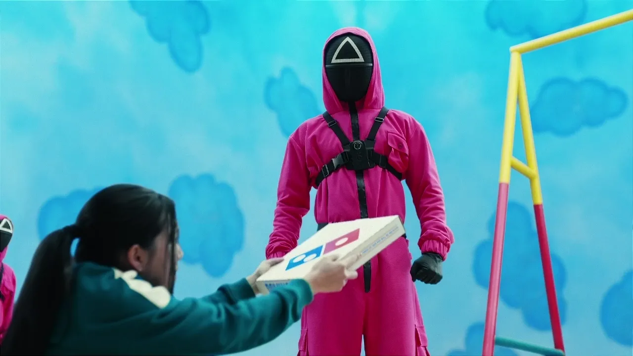 A Squid Game guard receiving a Domino&rsquo;s pizza in the partnership spot