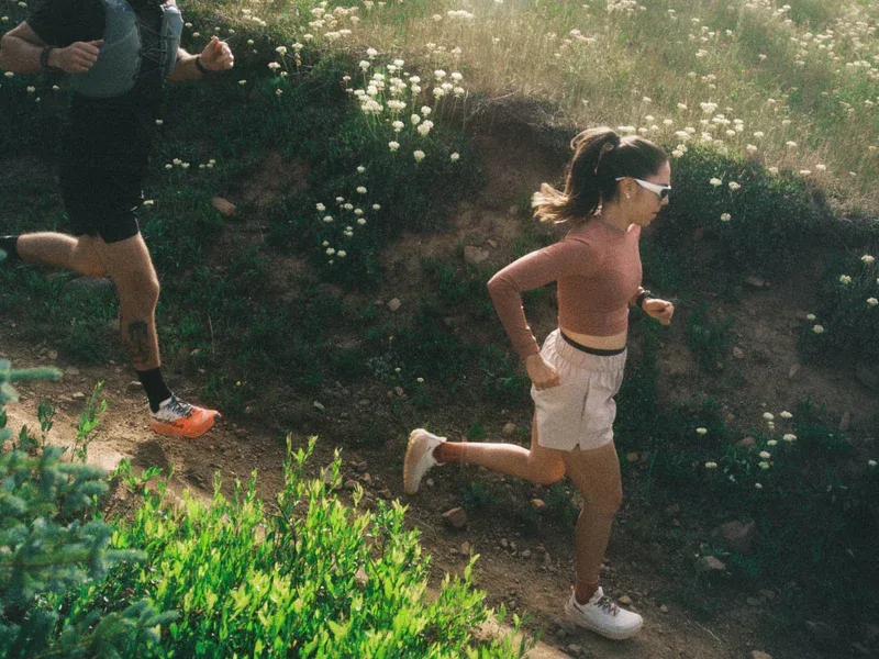 Two trail runners on a wildflower hillside